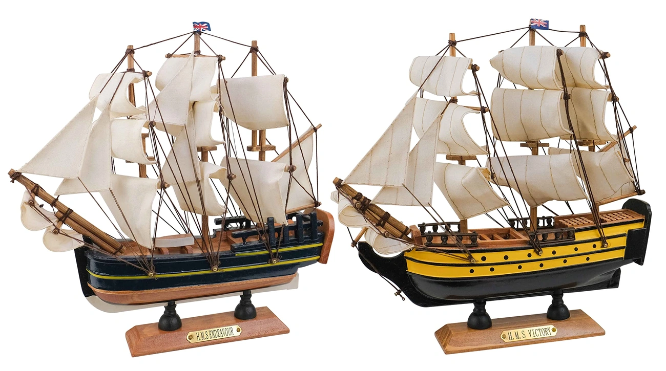 Two detailed wooden model sailing ships, HMS Endeavour and HMS Victory, with white sails and British flags.